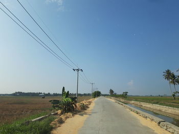 Road amidst field against sky