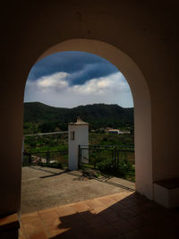 Entrance of building against sky seen through arch door