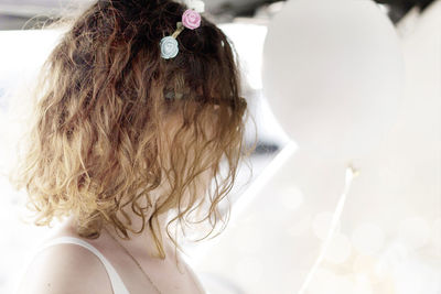 Side view of woman standing by white balloons at party