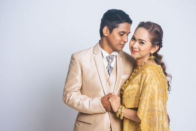 Happy friends standing against white background