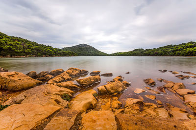 Scenic view of rocks in lake against sky