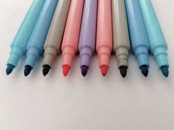 Close-up of colored pencils over white background