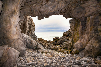 Rock formations on sea shore against sky