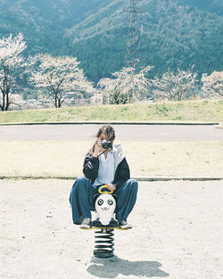 Full length of woman sitting on mountain