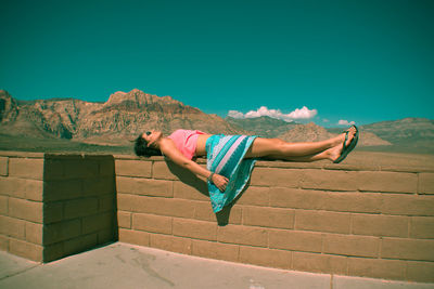 Low angle view of woman standing against wall