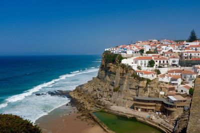 Panoramic view of sea and buildings against clear blue sky