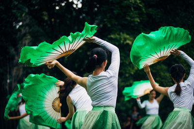 Girls performing with green hand fans