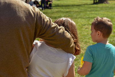 Rear view of father with children walking in park