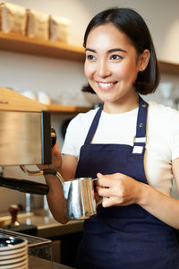 Portrait of smiling young woman using mobile phone