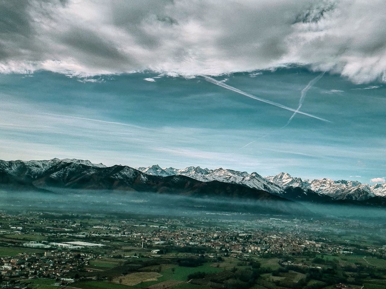 AERIAL VIEW OF TOWNSCAPE AND MOUNTAINS AGAINST SKY