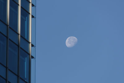 Low angle view of moon against clear blue sky