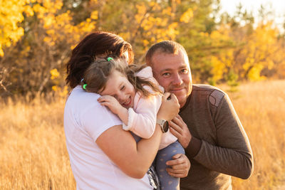 Happy family spending good time in nature in autumn