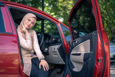 Young woman in red car