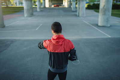 Rear view of man checking time while standing on street