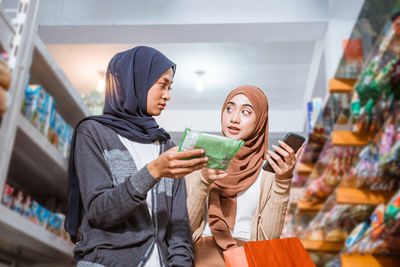 Portrait of smiling young woman standing in store