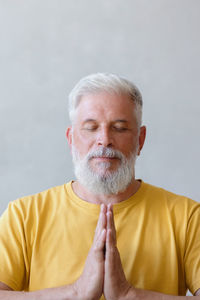 Mature man meditating at home