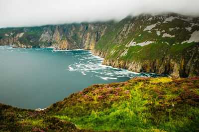 Scenic view of mountains by sea