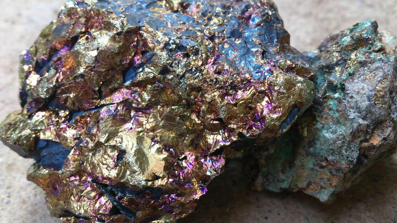 CLOSE-UP OF BLUE ROCKS ON ROCK AGAINST WALL