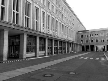 Street by buildings against sky in city