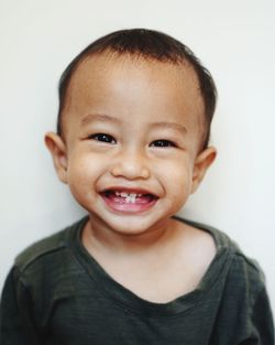 Close-up portrait of cute boy against white background