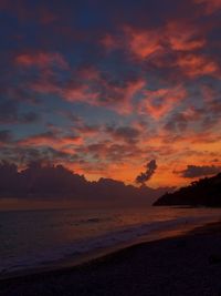 Scenic view of sea against dramatic sky during sunset