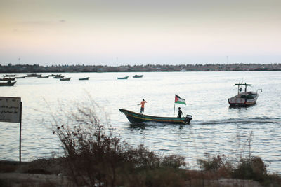 Boats in river against sky