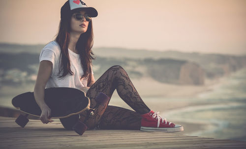 Beautiful young girl with her skateboard