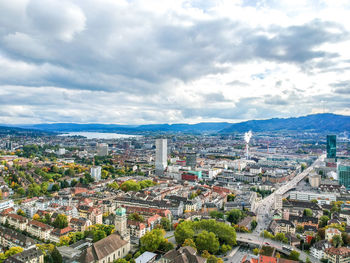 Aerial view of cityscape against cloudy sky