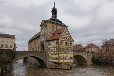 Arch bridge over river against buildings