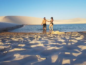 Man and woman standing in sea at beach