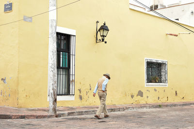 Full length of man standing against building