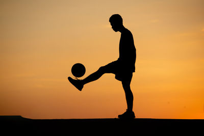 Silhouette man against sunset sky