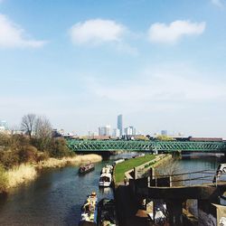 Bridge over river against cloudy sky