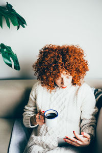 Woman sitting on sofa at home