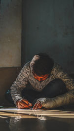 Man writing while sitting on floor