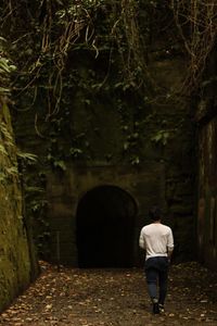 Rear view of man walking against tunnel