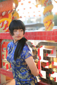 Young woman looking away while standing at temple