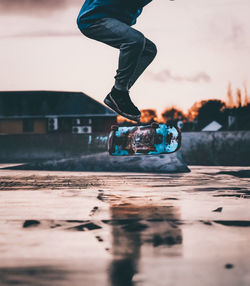 Low section of man skateboarding on street