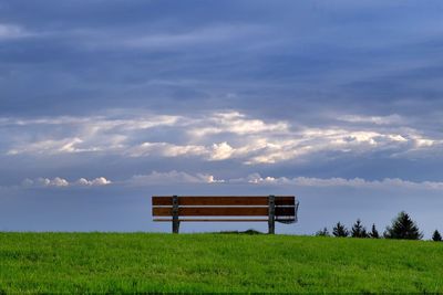 Scenic view of grassy field against cloudy sky