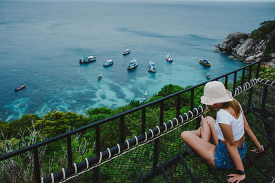 Woman sitting at observation point against sea