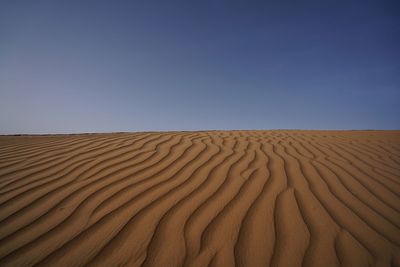 Scenic view of desert against clear blue sky