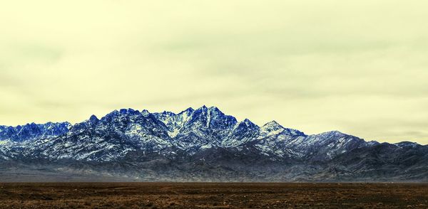 Scenic view of snow covered mountains against sky