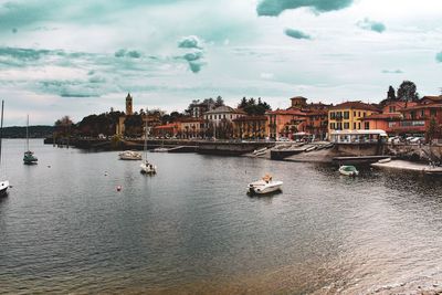 Sailboats in river with buildings in background