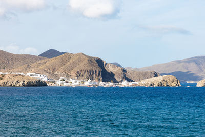 Scenic view of sea and mountains against sky