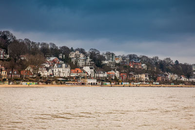 Scenic view of town by sea against sky