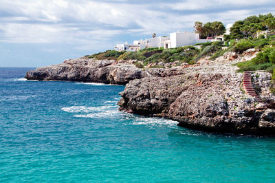 Scenic view of sea by buildings against sky