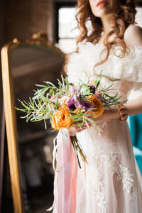 Midsection of woman holding flower bouquet