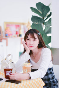 Portrait of young woman sitting on table