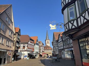 Street amidst buildings against clear sky