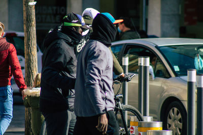 Rear view of people walking on street in city